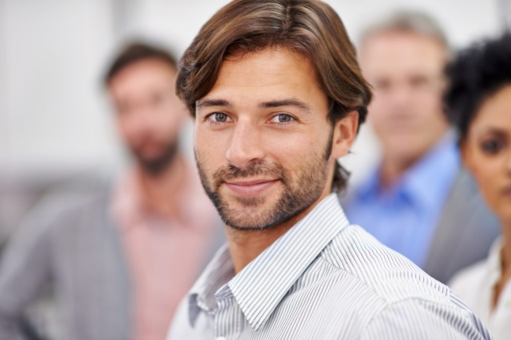 Confident looking young man with a smile and dressed in casual work attire. Pump Up Your Male Sexual Energy With Weight Training