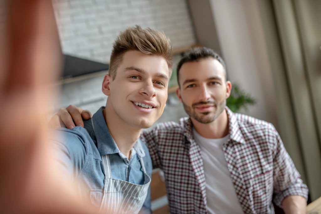 Attractive young gay couple looking happy together. Pump Up Your Male Sexual Energy With Weight Training